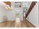 Spacious living room with wood flooring, a staircase with wood railing, and natural light at 12 Big Buck Trl, Ormond Beach, FL 32174