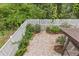 Private brick patio area with a white picket fence, surrounded by lush greenery and landscaping at 12 Big Buck Trl, Ormond Beach, FL 32174