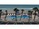 Outdoor pool area with palm trees, lounge chairs, and beach views for ultimate relaxation and resort-style living at 1233 S Atlantic Ave # 3070, Daytona Beach, FL 32118