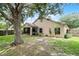 An inviting backyard with mature trees offering shade and a screened porch connected to the home at 25216 Ironwedge Dr, Sorrento, FL 32776