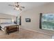 This spacious bedroom features neutral paint, a ceiling fan, and ample natural light from a large window at 25216 Ironwedge Dr, Sorrento, FL 32776