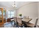 Elegant dining room with a chandelier, a large window, and seating for four at 25216 Ironwedge Dr, Sorrento, FL 32776