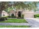 Charming single-story home with a well-manicured lawn, a two-car garage, and beautiful, mature trees at 25216 Ironwedge Dr, Sorrento, FL 32776