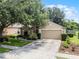 Lovely home with a well-maintained lawn, a two-car garage, and manicured landscaping at 25216 Ironwedge Dr, Sorrento, FL 32776