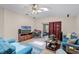 Cozy living room with wood-look floors, ceiling fan, and sliding glass doors to the patio at 25216 Ironwedge Dr, Sorrento, FL 32776