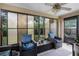 Relaxing sunroom offering comfortable seating, a ceiling fan, and a view of the backyard at 25216 Ironwedge Dr, Sorrento, FL 32776