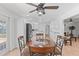 Bright dining area boasts a ceiling fan and round table, seamlessly connects to a modern, white kitchen at 321 Scotland Dr, Daytona Beach, FL 32117