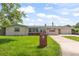 Charming single-story home featuring a well-manicured front lawn and a long driveway leading to a detached garage at 321 Scotland Dr, Daytona Beach, FL 32117