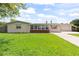 Charming single-story home featuring a lush green lawn and a welcoming facade at 321 Scotland Dr, Daytona Beach, FL 32117