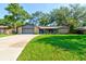 Charming single-story home with stone accents, a well-maintained lawn, and a welcoming blue front door at 35 Whippoorwill Ln, Ormond Beach, FL 32174