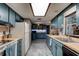 Bright kitchen with blue cabinets, stainless appliances, and tile flooring at 35 Whippoorwill Ln, Ormond Beach, FL 32174