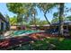 Backyard pool area featuring lush landscaping, outdoor seating, and a charming pergola at 35 Whippoorwill Ln, Ormond Beach, FL 32174