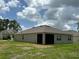 Exterior view of the backyard featuring a screened-in lanai and lush green lawn at 551 Shaelyn Pl, Deland, FL 32724
