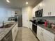 Well-equipped kitchen featuring stainless steel appliances, granite countertops, and white cabinets at 551 Shaelyn Pl, Deland, FL 32724
