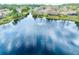 Aerial view of a serene lake with a fountain surrounded by houses and trees at 1 Crooked Bridge Way, Ormond Beach, FL 32174