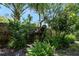 Artistic backyard with a metal horse statue, surrounded by ferns, trees, and a wooden fence in a quiet retreat at 1 Crooked Bridge Way, Ormond Beach, FL 32174