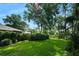 Expansive backyard with green lawn, mature trees, and lush hedges, offering privacy and a serene outdoor setting at 1 Crooked Bridge Way, Ormond Beach, FL 32174