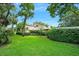 Lush backyard featuring mature trees, green lawn, and privacy hedging at 1 Crooked Bridge Way, Ormond Beach, FL 32174