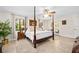 Calm bedroom with a ceiling fan, a four-poster bed, and access to the backyard at 1 Crooked Bridge Way, Ormond Beach, FL 32174