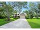 Traditional home boasting a manicured lawn, mature trees, and a two-car garage with brick accents at 1 Crooked Bridge Way, Ormond Beach, FL 32174