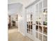 Hallway with french doors leading to a bright living space, showcasing the home's open layout at 1 Crooked Bridge Way, Ormond Beach, FL 32174