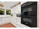 Bright kitchen features stainless steel appliances, marble countertops, and white cabinetry at 1 Crooked Bridge Way, Ormond Beach, FL 32174