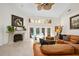 Bright living room with fireplace, leather couch, and ample light, with views of the outdoor pool area at 1 Crooked Bridge Way, Ormond Beach, FL 32174