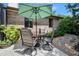 Charming outdoor patio with a round table, seating for four, and a green umbrella in a brick patio setting at 1 Crooked Bridge Way, Ormond Beach, FL 32174
