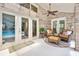 Cozy sunroom with brick walls, ceiling fan, and comfortable seating, with a view of the pool area at 1 Crooked Bridge Way, Ormond Beach, FL 32174