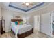 Bedroom with tray ceiling, ceiling fan, neutral walls and an ensuite bathroom and walk in closet at 206 St Somewhere Dr, Daytona Beach, FL 32124