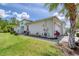 Exterior shot of a bright white home with well-maintained landscaping, showing its side profile and yard at 206 St Somewhere Dr, Daytona Beach, FL 32124