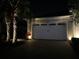 Well-lit garage exterior with manicured landscaping at night at 206 St Somewhere Dr, Daytona Beach, FL 32124