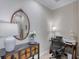 This is a brightly illuminated office space featuring a black desk, white lamp and decorative mirror hanging on the wall at 206 St Somewhere Dr, Daytona Beach, FL 32124