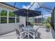 Spacious screened patio with outdoor seating, a large patio umbrella and brick flooring at 206 St Somewhere Dr, Daytona Beach, FL 32124