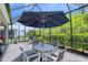 Comfortable screened patio featuring outdoor dining set, shade and serene views at 206 St Somewhere Dr, Daytona Beach, FL 32124