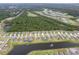 An overhead view shows homes in a neighborhood bordered by greenery, a pond, and trees at 2861 Monaghan Dr, Ormond Beach, FL 32174
