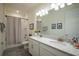 Bathroom featuring a double vanity, large mirror, shower with curtain and neutral walls at 2861 Monaghan Dr, Ormond Beach, FL 32174