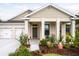 Charming home featuring a manicured lawn, covered porch, and a two-car garage, creating a welcoming curb appeal at 2861 Monaghan Dr, Ormond Beach, FL 32174