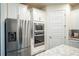 Kitchen with stainless steel refrigerator, built-in oven and microwave, and white cabinetry at 2861 Monaghan Dr, Ormond Beach, FL 32174