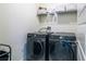 Laundry room featuring new front load washer and dryer with overhead shelving for storage at 2861 Monaghan Dr, Ormond Beach, FL 32174