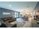 Open-concept living room with abundant natural light, a stylish sectional, and seamless flow to the dining area at 2861 Monaghan Dr, Ormond Beach, FL 32174