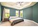 Bedroom with tray ceiling, neutral carpet, and windows with privacy blinds at 2861 Monaghan Dr, Ormond Beach, FL 32174