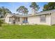 Inviting backyard featuring a fire pit, blue chairs and a gas grill at 2910 Yule Tree Dr, Edgewater, FL 32141