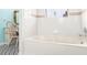 Bright bathroom featuring a white tub, and a tiled wall with a decorative accent stripe at 2910 Yule Tree Dr, Edgewater, FL 32141