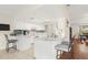 Bright kitchen with white cabinetry, a breakfast bar, and tiled floors, open to the adjacent dining area at 2910 Yule Tree Dr, Edgewater, FL 32141