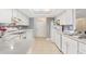 Efficient kitchen with white appliances and cabinets, and neutral tile flooring at 2910 Yule Tree Dr, Edgewater, FL 32141