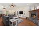 Inviting living room with a fireplace, vaulted ceilings, hardwood floors, and comfortable seating, with access to dining area at 2910 Yule Tree Dr, Edgewater, FL 32141