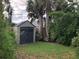 Spacious backyard featuring a useful shed, bordered by mature landscaping and lush greenery at 33 Camellia Dr, Ormond Beach, FL 32176