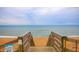 Beach access stairs lead to sandy shores and the ocean for a relaxing beach experience at 33 Camellia Dr, Ormond Beach, FL 32176