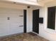 Close-up of front entrance with brick-paved drive, black door, and attached garage at 33 Camellia Dr, Ormond Beach, FL 32176